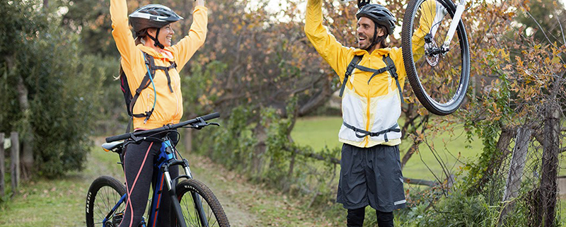 Mannen staan vrolijk met hun fiets in hun handen geen last van rugklachten